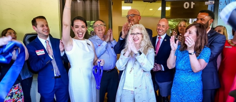 image of a group of people cheering at a ribbon cutting ceremony