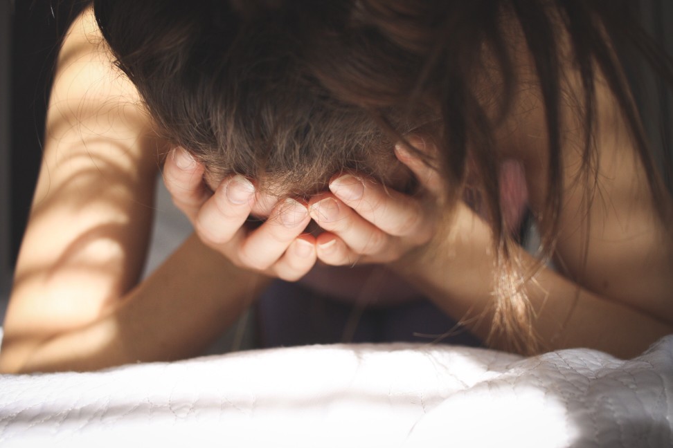 image of a stressed young woman covering her face about her eating disorder