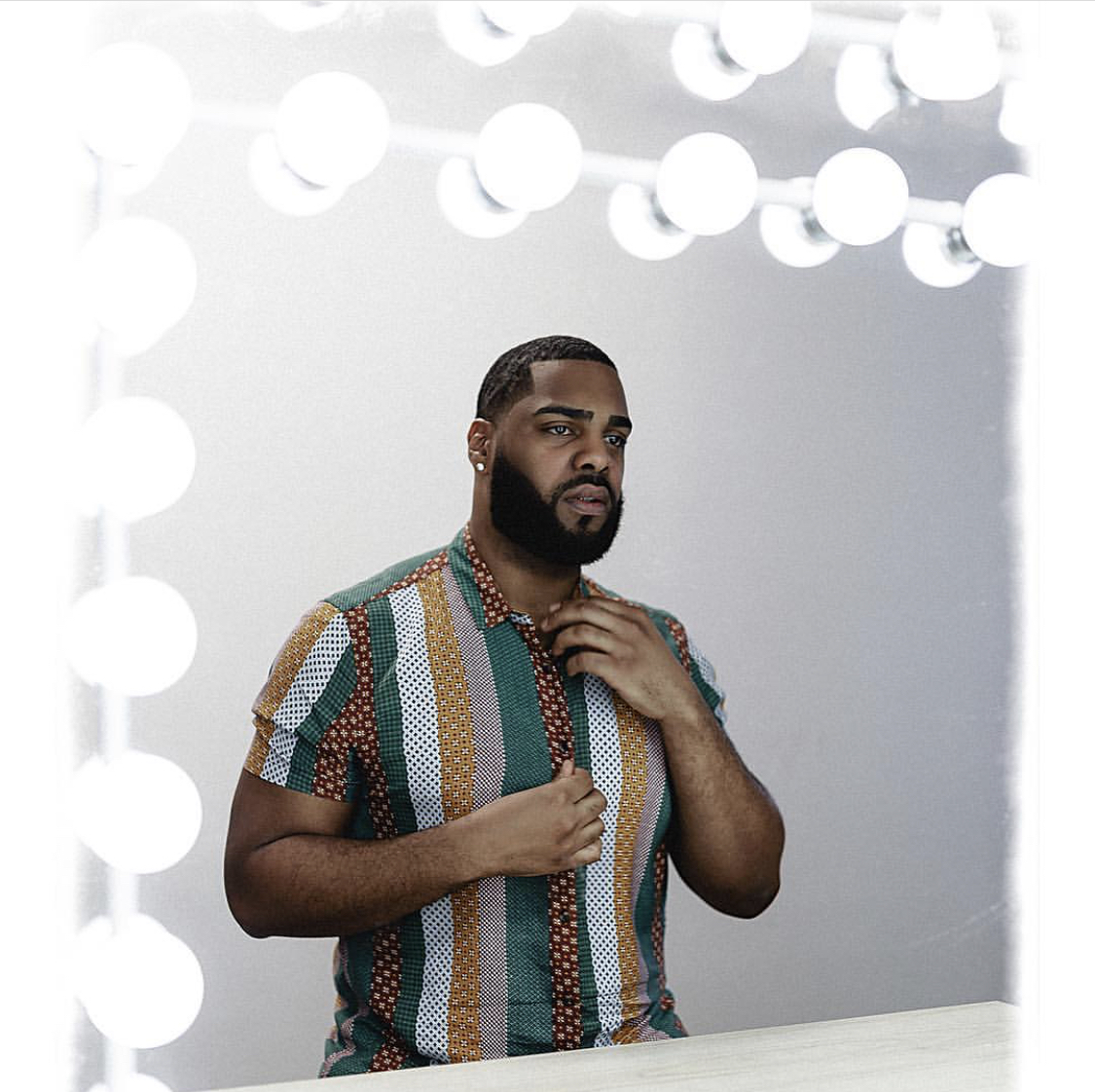 image of a young man looking serious at himself in the mirror