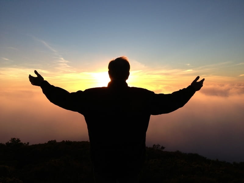 image of the silhouette of a man with his arms spread wide representing acceptance