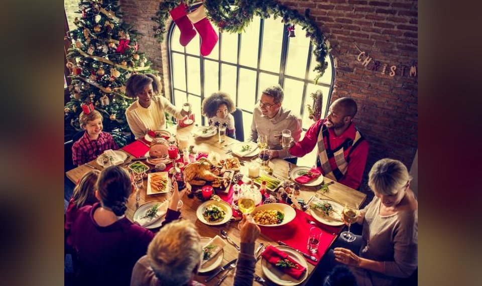image of a group of people eating around a festive table for christmas