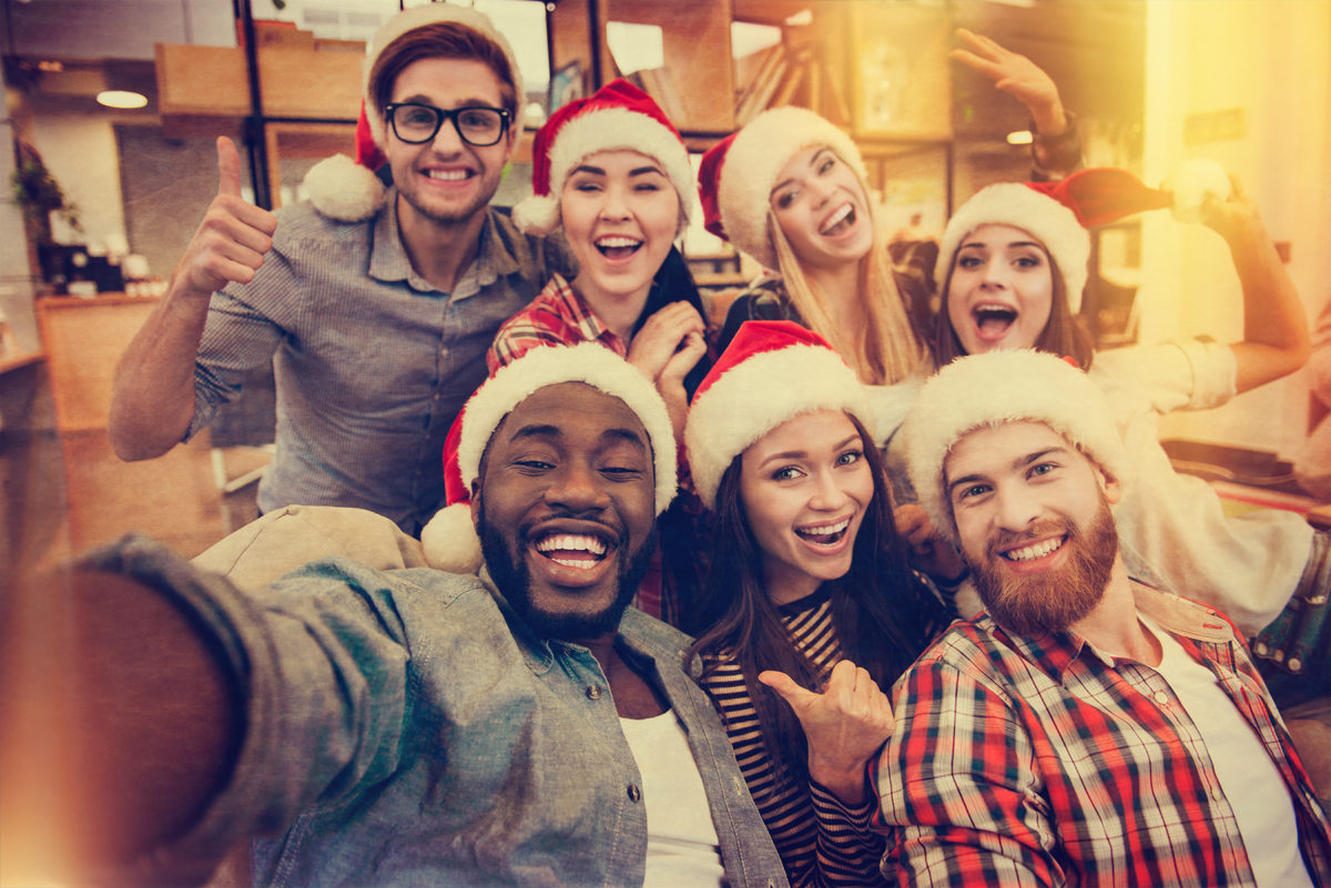 image of a group of young adults posing with santa claus hats