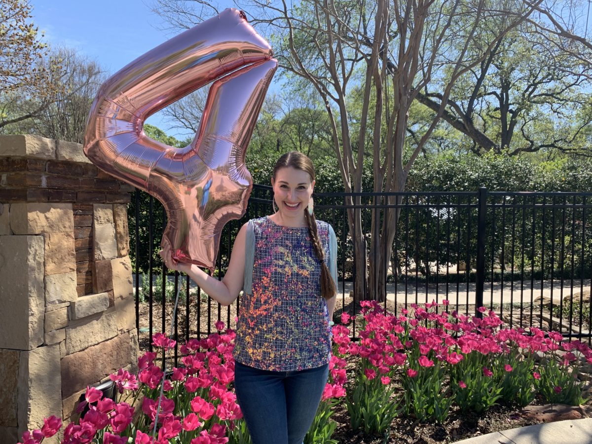 image of a young woman holding a large balloon shaped like the number 4