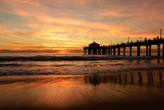 image of a silhouette of a pier against a bright pink and blue sunset