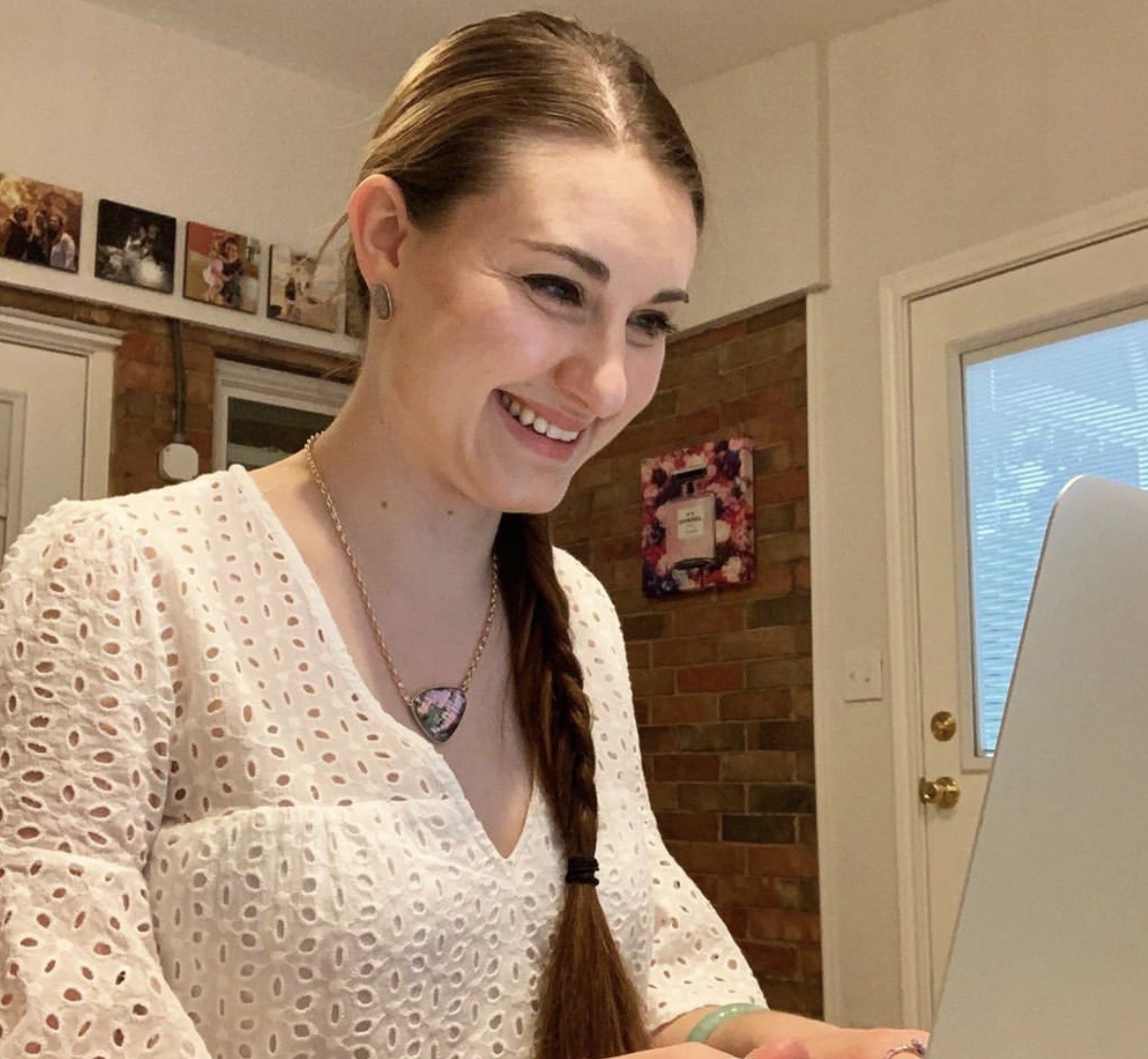 image of a young woman looking at her computer with an excited expression