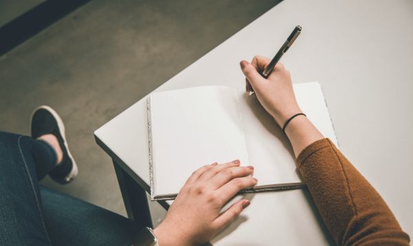 image of a woman writing in a blank journal about eating disorders
