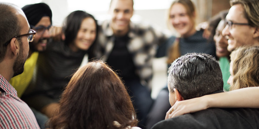 group of individuals huddled together smiling