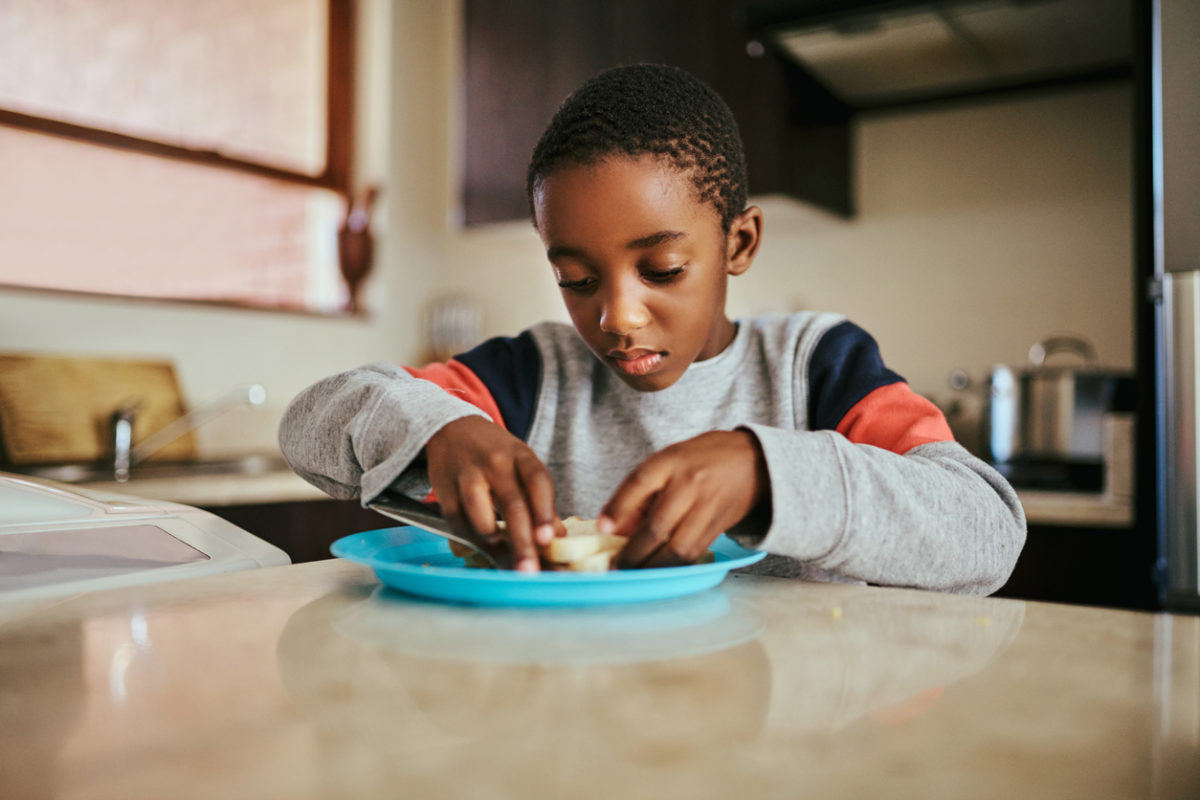 little boy eating a sandwich at home