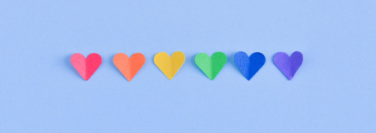 blue background with rainbow of paper hearts