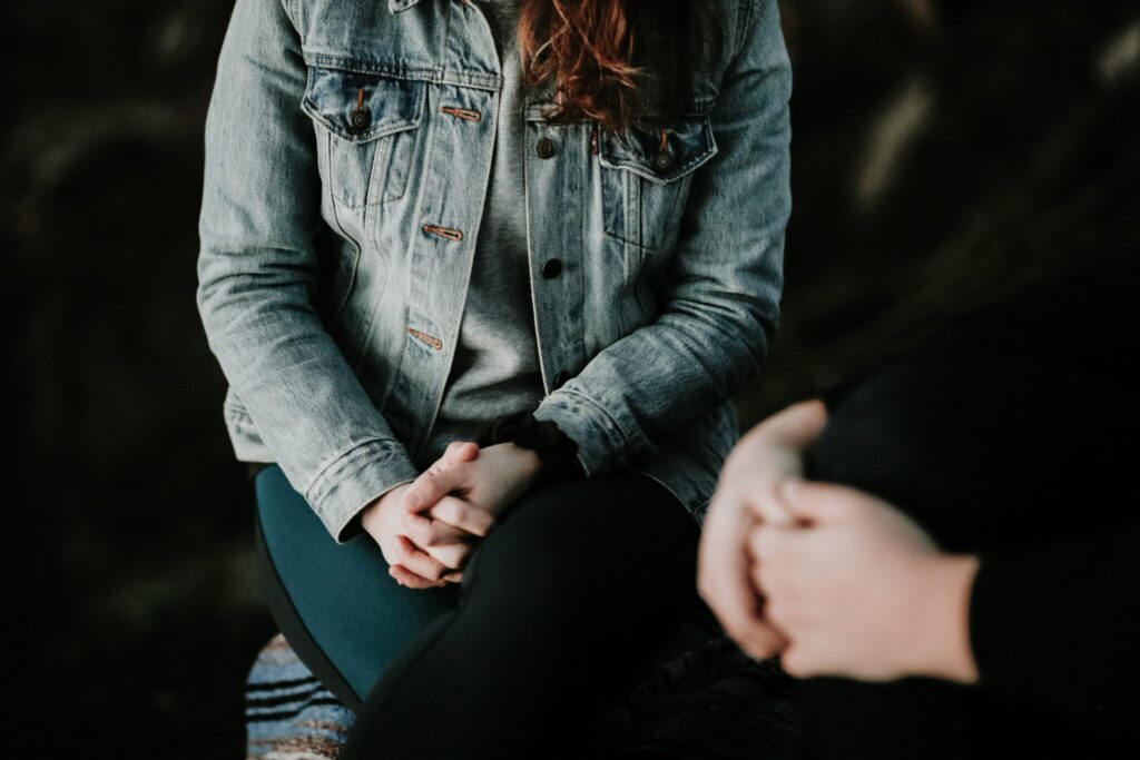 woman sitting cross-legged holding her hands