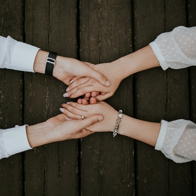 two people holding hands across a table