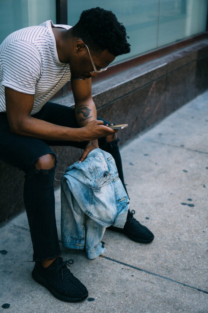 man sitting down looking at phone