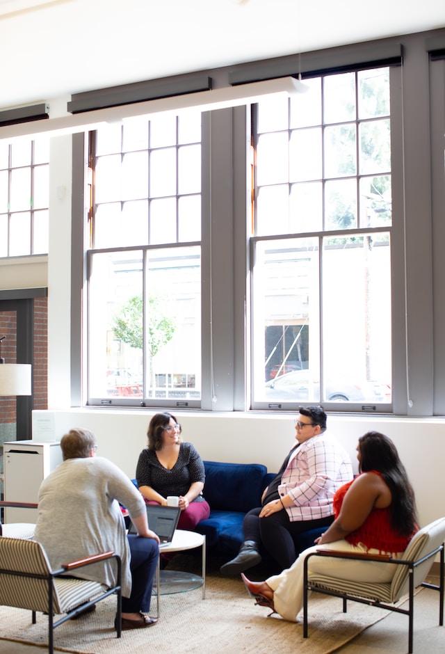 group sitting in chairs in a circle talking in a sunlit room