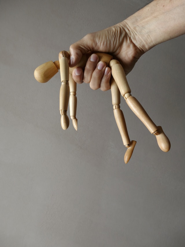 hand holding wooden doll