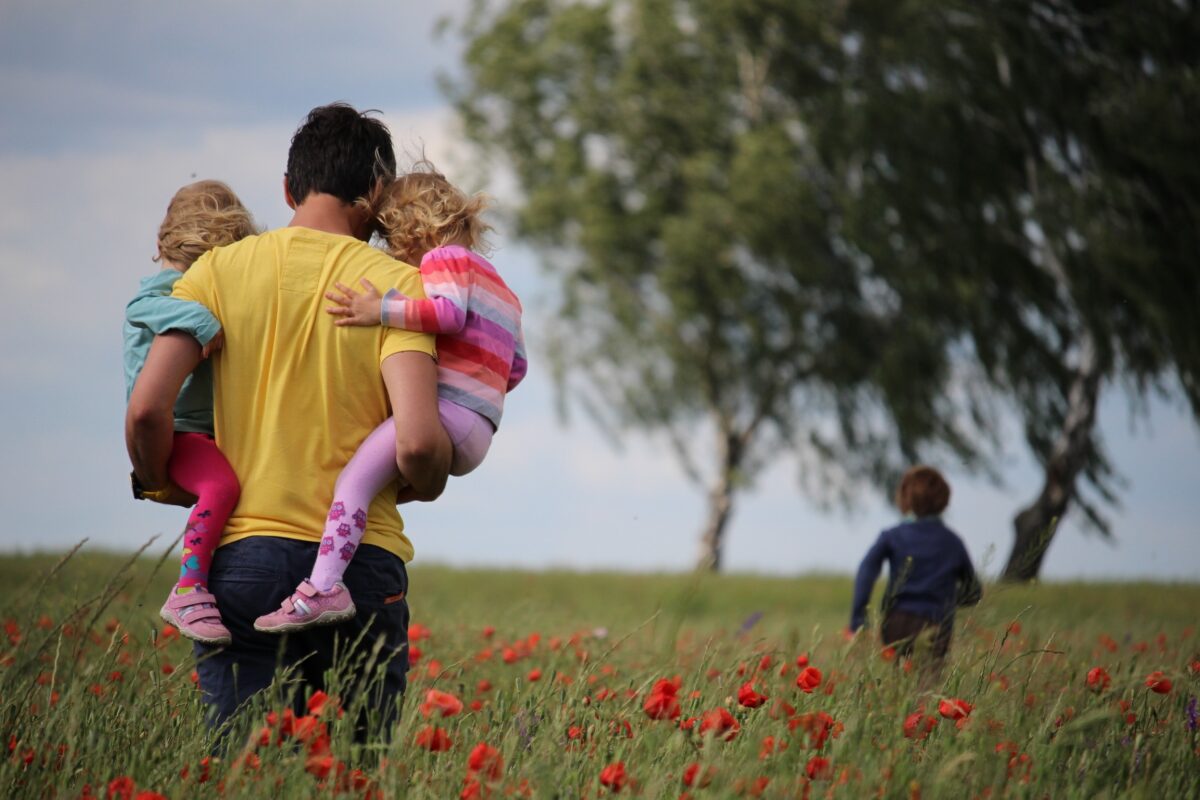 man holding child in field