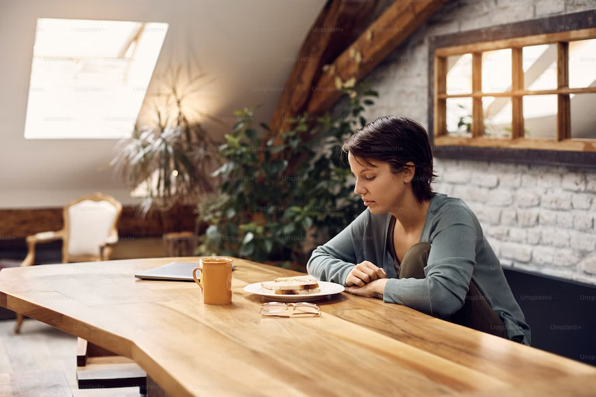 woman looking sadly at table