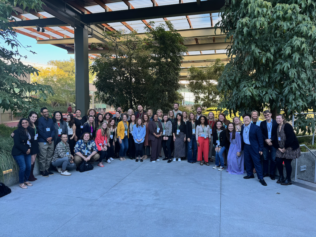Group of about 50 people stand and pose for photo