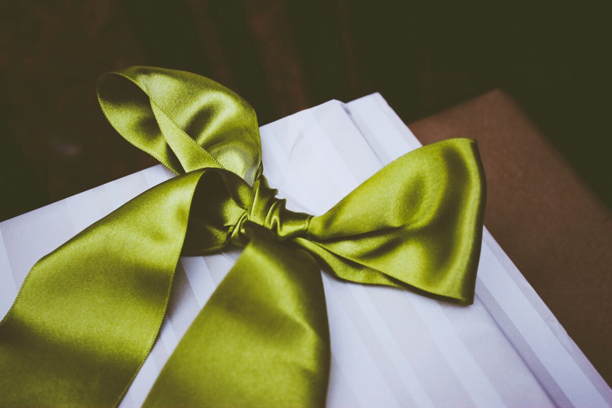 Green ribbon for mental health awareness on neutral background.