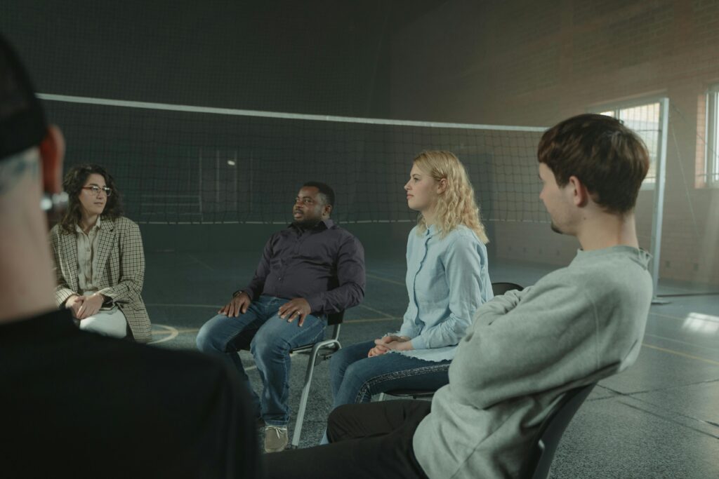 Group therapy in a circle, calm/hopeful mood.