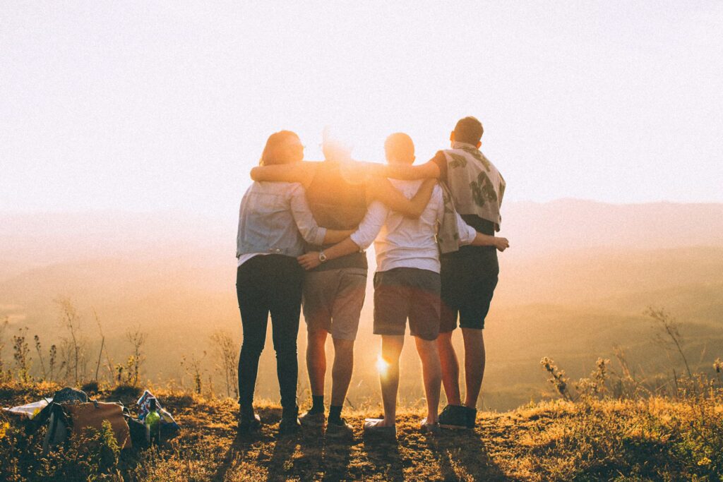 a group of people is sunlight from behind, they are facing away (four people)