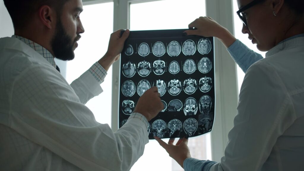 Two medical professionals look at a neuroimaging scan together