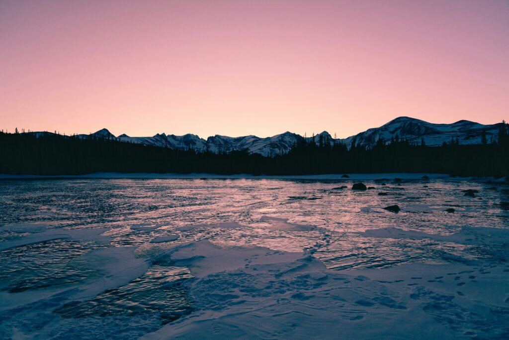 View across a frozen lake towards the treeline.