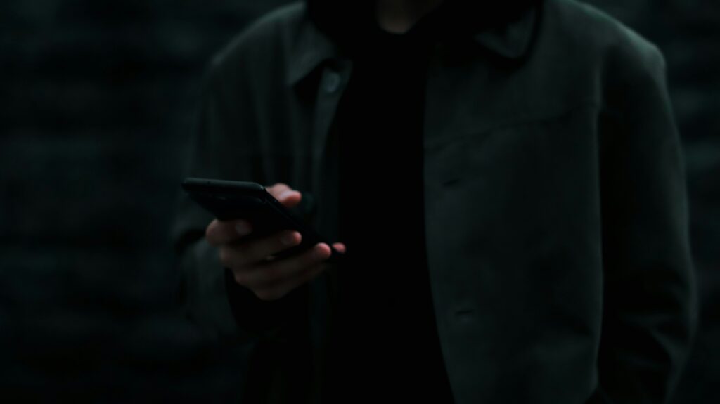 man holding a phone in his hand in dark room