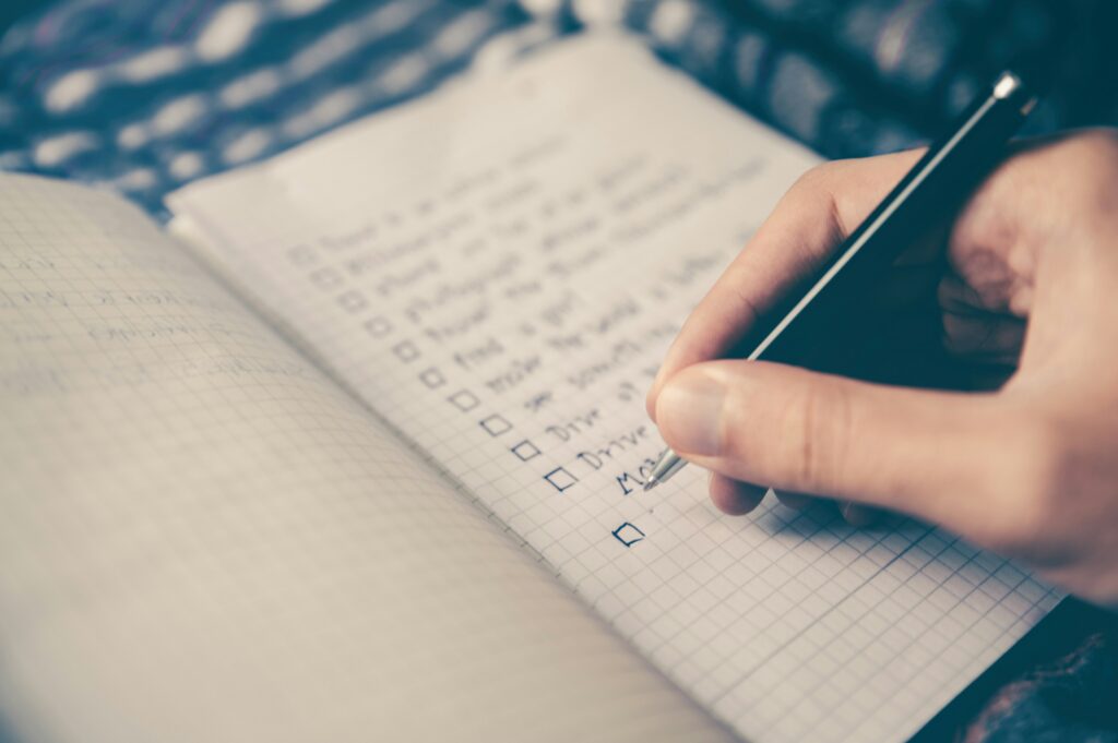 Close up shot of a person making a list in a notebook.